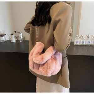 Detail view of a soft pink faux fur crossbody bag with an elegant gold chain strap