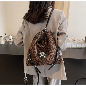 Detail der hobo-tasche mit leopardmuster m-metallsymbol und schwarzem lederriemen