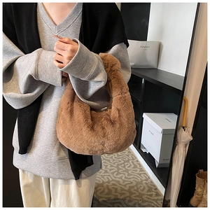 Detailed close-up of brown faux fur dumpling bag with soft texture and hobo handle