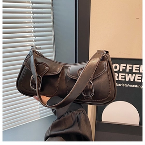 Detail of dark brown vintage faux leather shoulder bag with front double pockets and buckles