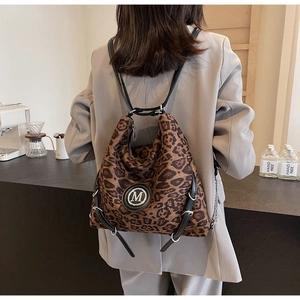 Details eines Vintage-Rucksacks mit Leopardenmuster und M-Logo am Modell