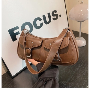 Close-up of retro brown shoulder bag featuring dual buckle pockets and premium PU leather