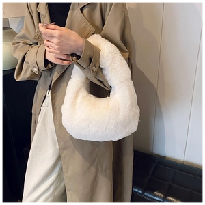 Close-up of fluffy white faux fur texture on a minimalist dumpling shaped handbag