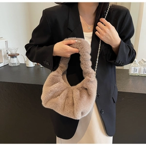 Detail of plush faux fur shoulder bag with chain strap and soft pleated texture