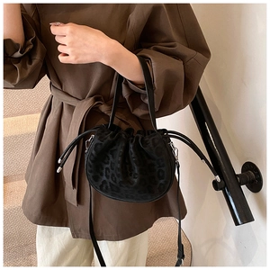 Detail der Leoparden-Beuteltasche mit Kordelzug und Ledergriff getragen am Modell