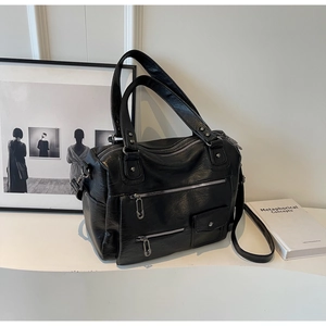 Détail du sac Boston en similicuir noir avec fermetures éclair et ferrures argentées