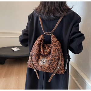 Detailansicht eines Vintage-Rucksacks mit Leopardenmuster, M-Logo und Lederriemen