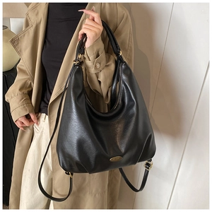 Detail of black multi-functional PU leather tote showing golden hardware and shoulder straps