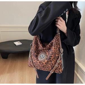 Detail der Hobo-Tasche mit braunem Leopardenmuster und Metall-M-Logo am Kettenriemen