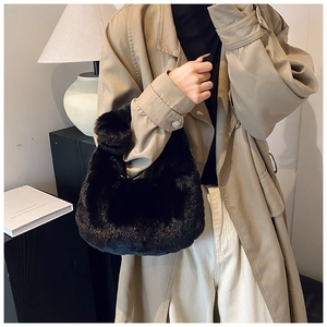 Detail of black faux fur handbag showing soft plush texture and integrated handle