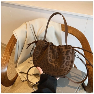 Detail der Leopard-Beuteltasche mit Kordelzug auf einem klassischen Holzstuhl