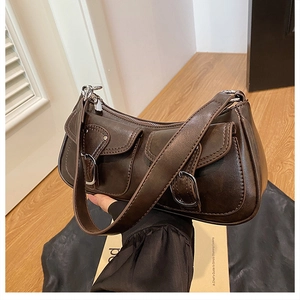 Detailed view of dark brown vintage faux leather shoulder bag with silver buckle pockets