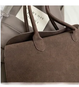 Detail of reinforced handle stitching on vintage dark brown suede tote bag