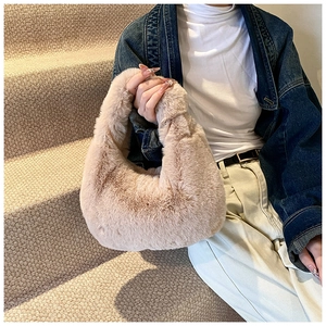 Close-up of plush mauve faux fur dumpling bag held by model on minimalist stairs