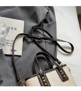 Détail de la bandoulière réglable et des rivets dorés sur le sac à bandoulière pour femme