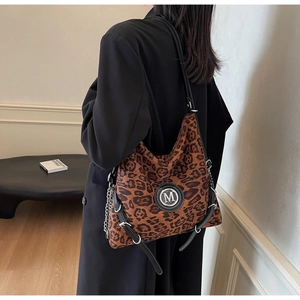 Detailansicht der großen Shopper-Tasche mit Leopardenmuster, M-Logo aus Metall und Riemen