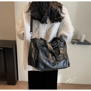 Gros plan sur un grand sac de voyage rétro noir avec plusieurs poches et ferrures argent