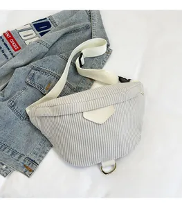 Détail macro d'un sac bandoulière en velours côtelé gris avec sangle large et anneau