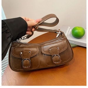Detail of vintage brown shoulder bag with dual flap pockets and silver metal buckles