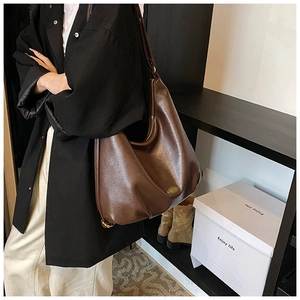 Detail view of deep brown vintage tote bag showing premium leather texture and hardware