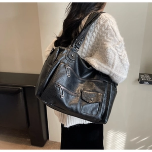 Détail d'un grand sac fourre-tout vintage en similicuir noir avec de multiples poches
