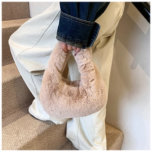 Close-up of soft plush dumpling handbag in apricot beige color for winter fashion