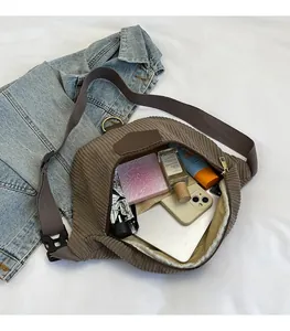 Détail du rangement spacieux pour objets essentiels dans le sac bandoulière en velours