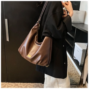 Detailed shot of large brown leather hobo bag with gold hardware and smooth zipper detail