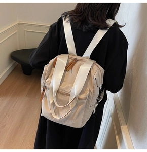 Back view of a person wearing the minimalist beige nylon backpack with wide straps