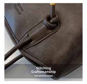 Detail of premium brown leather tote showing precision stitching and metallic accents
