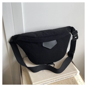 Détail du sac banane en velours côtelé noir montrant la texture et le patch logo gris