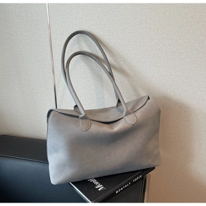 Close-up of minimalist grey suede tote bag showing soft matte texture and seamless design