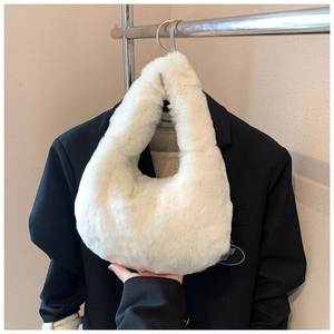 Close-up detail of plush white faux fur handbag texture on a stylish black blazer
