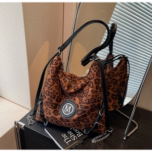 Detail des silbernen M-Logos und der Metallkette auf der Vintage-Leopard-Hobo-Tasche