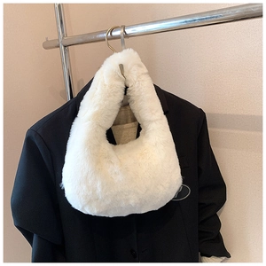 Detail of soft white faux fur plush handbag texture against a black blazer background