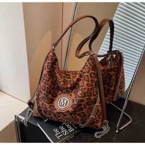 Detail der Shopper-Tasche mit Leopardenmuster, goldenem M-Logo und Metallkettenriemen