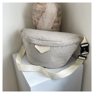 Vue détaillée du sac bandoulière en velours côtelé beige avec sangle réglable sur socle