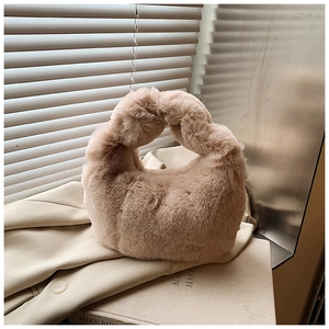 Detail of plush beige faux fur handbag featuring a twisted handle and soft texture