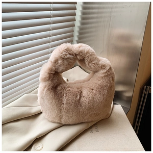 Detailed close-up of apricot plush dumpling bag texture on a stylish beige blazer