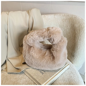 Detail of plush dumpling handbag with knot handle on artistic magazine background
