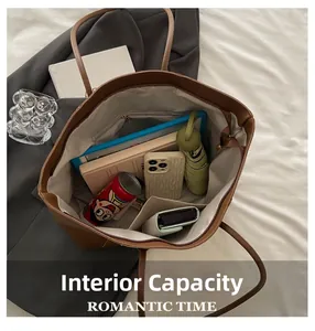 Internal capacity of large brown tote bag showing storage for tablet, books and phone