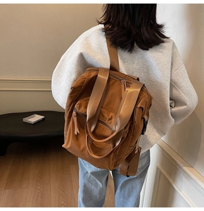 Rear view of a model carrying a brown waterproof nylon backpack with a zipper pocket
