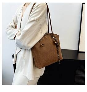 Detail of dark brown vintage tote bag featuring embossed logo and decorative braided rope