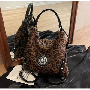 Detail des Metall-M-Logos auf brauner Hobo-Tasche mit Leopardenmuster und Ledergriff