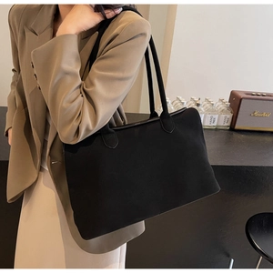 Close-up of matte black tote bag with slender straps and high-quality edge finishing