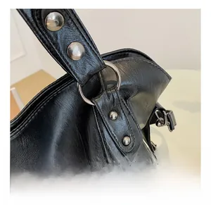 Close-up of durable silver metal ring and rivets on black leather tote bag strap