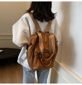 Rear view of a stylish caramel nylon backpack for women with multi-pocket layers