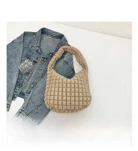 Detail shot of beige quilted puffer shoulder bag with a soft textured finish
