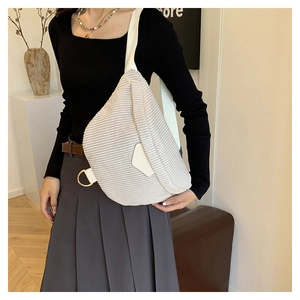 Détail de sac bandoulière en velours côtelé beige avec large sangle et anneau en D