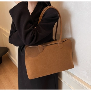Close-up of brown suede tote bag with matte texture and minimalist square design